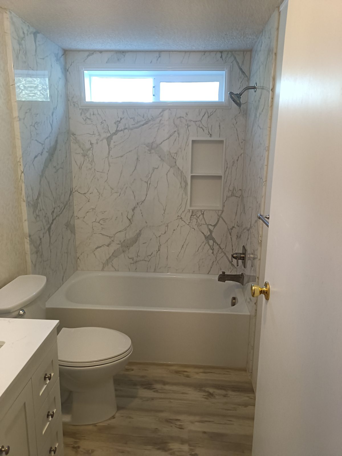 Complete bathroom remodel with marble-look tub surround, built-in niche, new vanity and flooring — Thor Builders, Southern Oregon