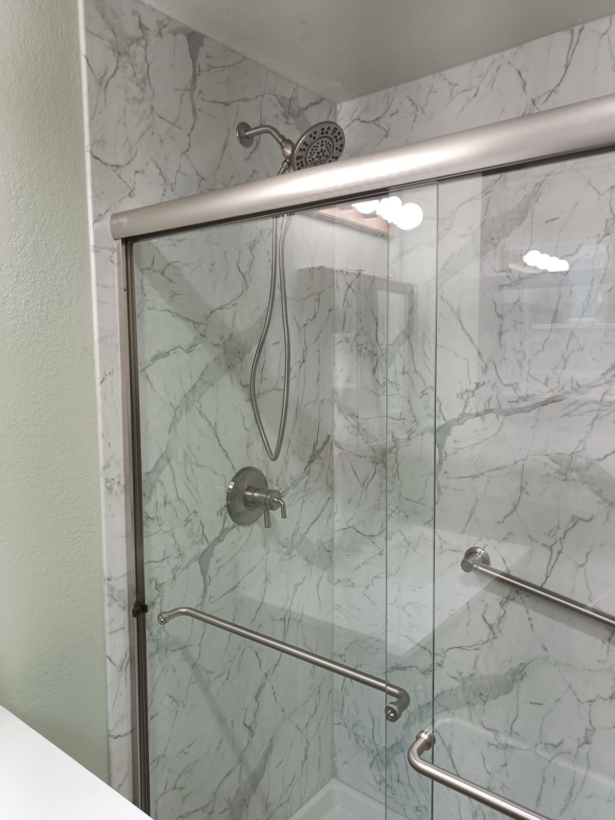 Tub and shower combination with brushed nickel sliding doors and sage green walls